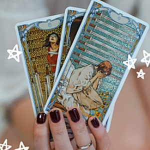 Mano sosteniendo cartas de tarot con el texto Qué Debes Hacer sobre fondo desenfocado